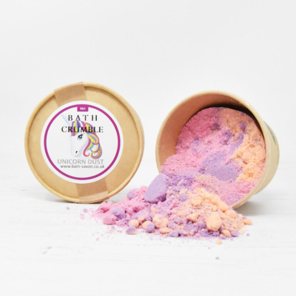 Bain and Savon bath crumble in Unicorn dust shown in paper pot with lid off and purple and orange bath crumble inside