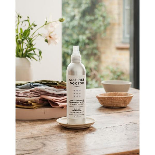 Crease release refreshing clothing spritz in aluminium bottle with spray top on a wooden kitchen surface