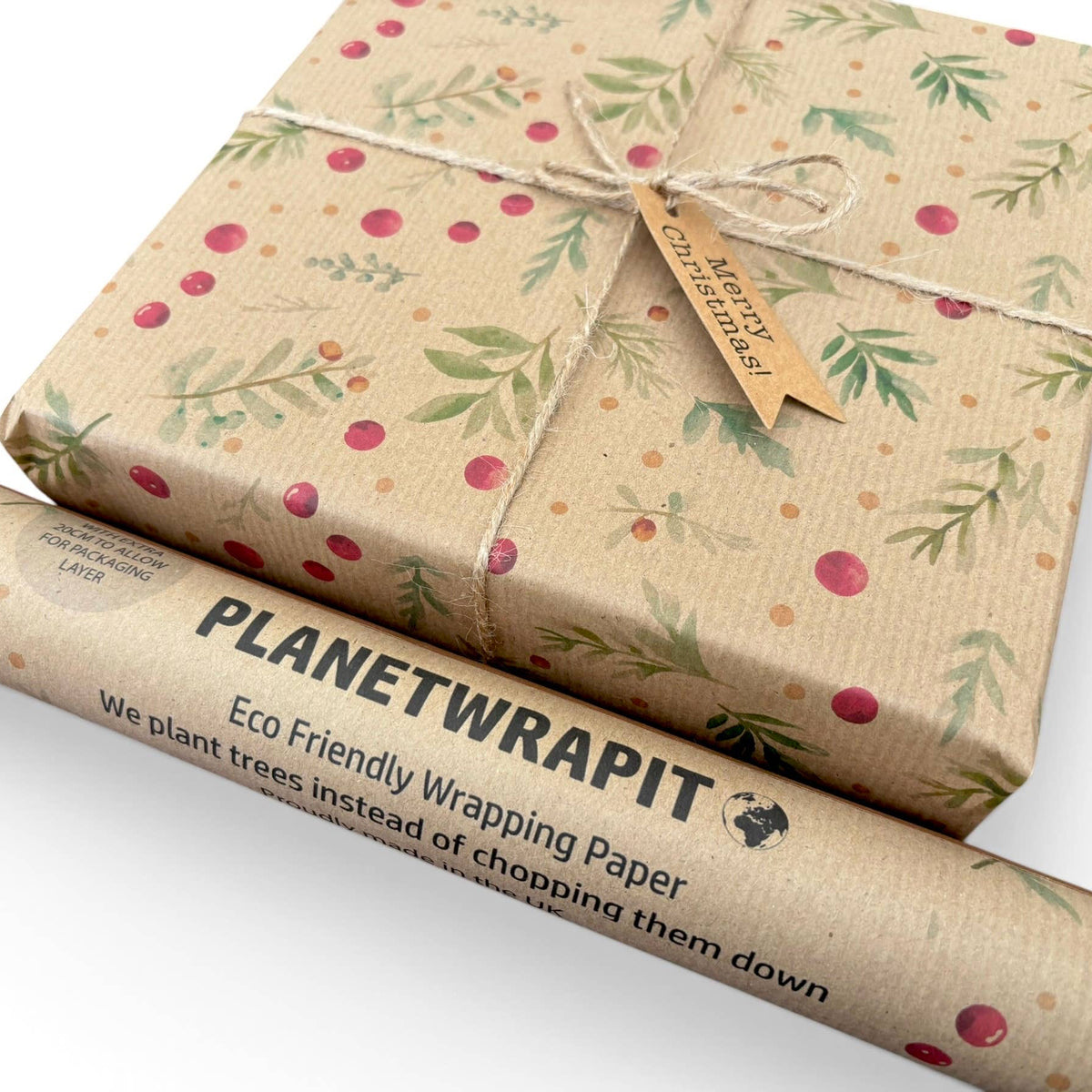 Planetwrapit Eco Friendly Wrapping Paper shown wrapped around a gift box and as a rolled tube on a white background. The wrapping paper has a natural kraft paper texture with a pattern of green leaves and red berries.