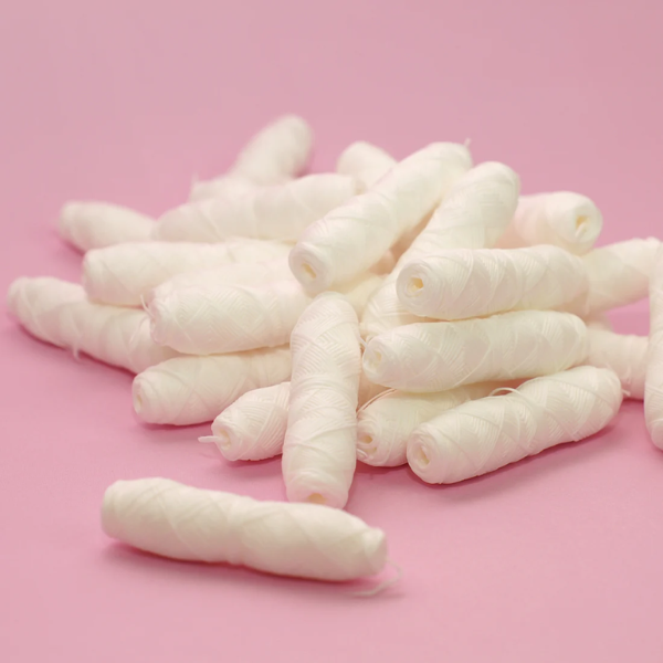 Lots of eco-friendly dental floss refills in a pile