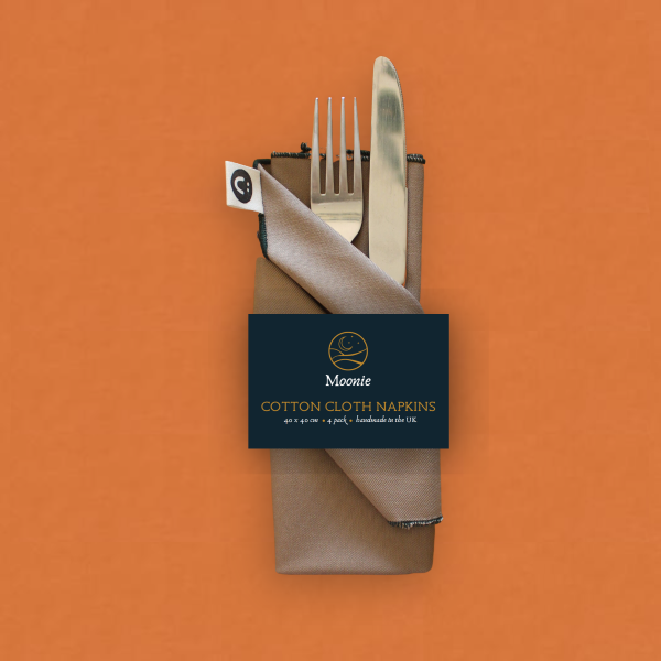 Reusable fabric napkins handmade by Moonie in pebble colour with some silver cutlery tucked inside
