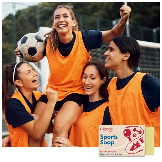 Group of women in sports clothing celebrating with a football, with Friendly Soap sports bar shown on an inset image