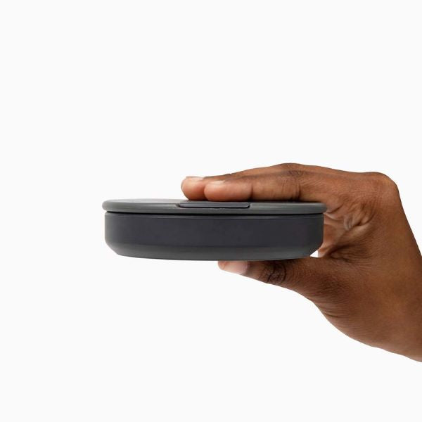 Collapsible cup 12oz shown in charcoal collapsed in a hand 