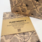 Planet Wrapit eco-friendly kraft wrapping paper with black floral design and PlanetWrapIt paper label shown alongside a wrapped parcel.