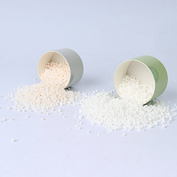Green cardboard cylinder box lids with white fragrance beads shown inside