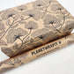 Planet Wrapit eco-friendly kraft wrapping paper with black floral design and PlanetWrapIt paper label shown alongside wrapped parcel.