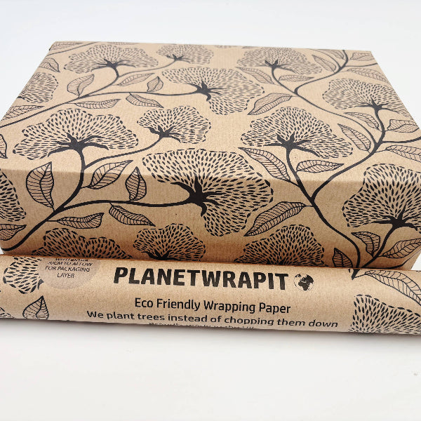 Planet Wrapit eco-friendly kraft wrapping paper with black floral design and PlanetWrapIt paper label shown alongside wrapped parcel.