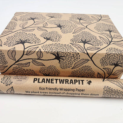 Planet Wrapit eco-friendly kraft wrapping paper with black floral design and PlanetWrapIt paper label shown alongside wrapped parcel.