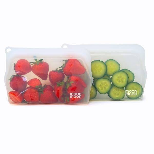 Reusable silicone food storage bags with strawberries and cucumbers on a white background