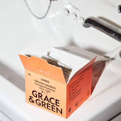 Box of Grace & Green organic bamboo liners on a sink shown with box open and liners inside