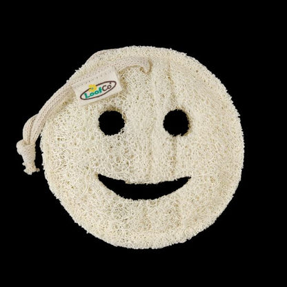 A round natural loofah sponge soap dish with a smiley face design, featuring a drawstring closure with a visible 'LoofCo' brand tag, set against a solid black background.