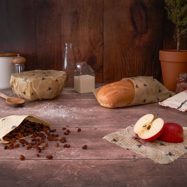 Beeswax wraps in use (wrapped round a bowl, wrapping bread, some dried fruit and an apple)
