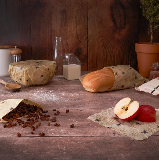 Beeswax wraps in use (wrapped round a bowl, wrapping bread, some dried fruit and an apple)