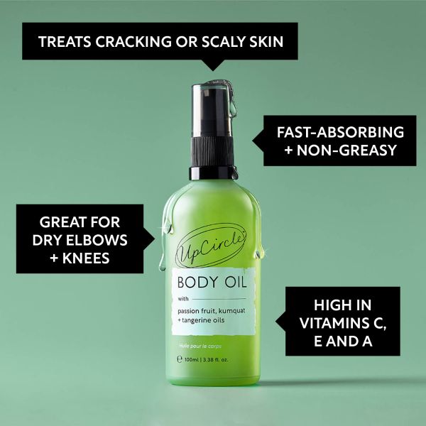 Green bottle of UpCircle body oil on a green background with text reading "Treats cracking or scaly skin; Fast-absorbing and non-greasy; great for dry elbows and knees; High in vitamins C, E and A"