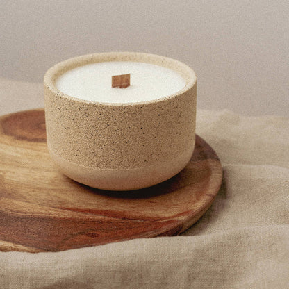 Reusable candle pot with candle refill inside on wooden plate