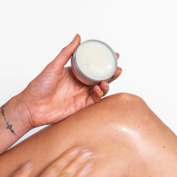 Corinne Taylor Chafe Away balm shown in a hand being applied to a leg