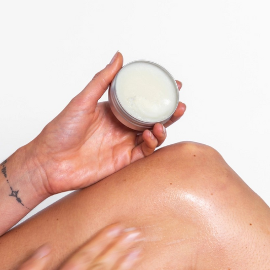 Corinne Taylor Chafe Away balm shown in a hand being applied to a leg