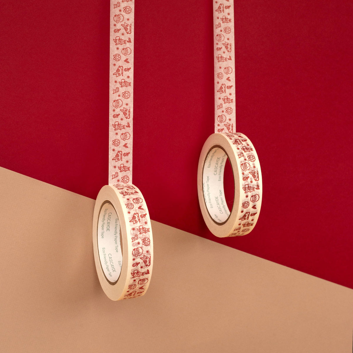 Two rolls of paper tape with a red Santa character pattern on a white background, hanging against a split red and beige background.