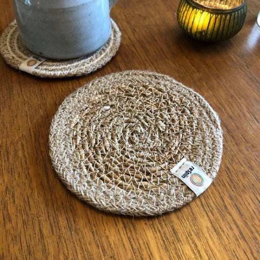 Round seagrass woven coaster with jute trim, on a wooden surface with a ReSpiin brand label.