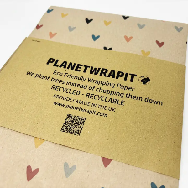 Eco-friendly wrapping paper from PlanetWrapit on brown kraft paper with colourful hearts and a paper label shown close up