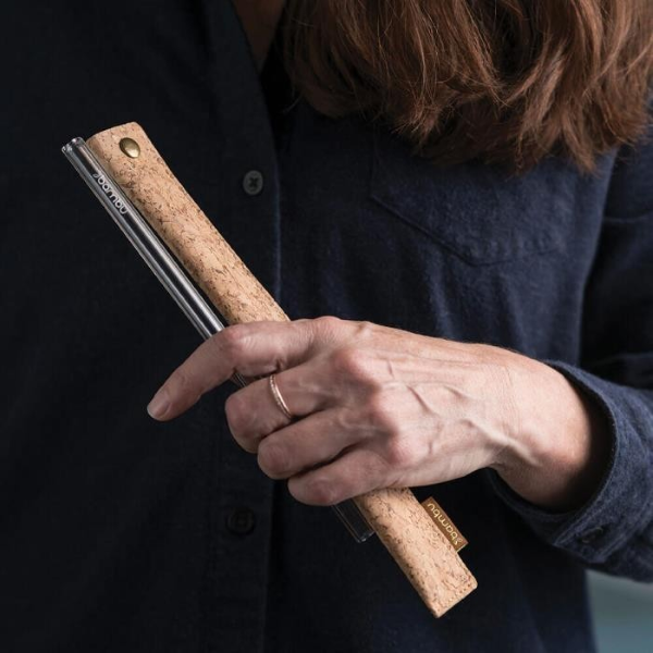 Cork sleeve for reusable straw shown held in person's hand