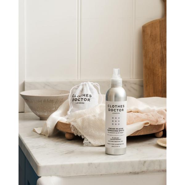 Crease release refreshing clothing spritz in aluminium bottle with spray top on a marble kitchen work surface
