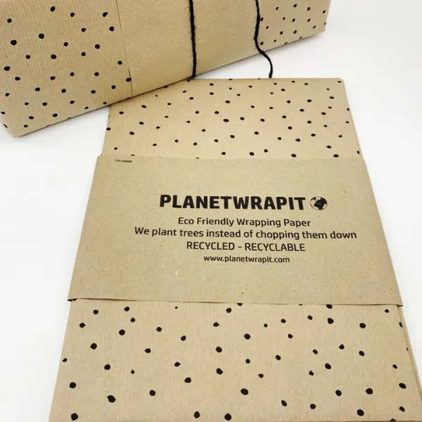 Eco-friendly wrapping paper from PlanetWrapit, brown kraft paper with little black dots shown alongside a wrapped parcel