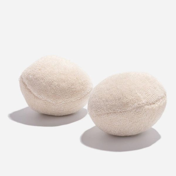 Two waste cotton dryer balls on a white background
