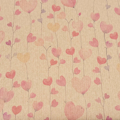 A Planet Wrapit eco-friendly wrapping paper shown close up with a brown kraft paper centre featuring pink, red, and orange hearts on a brown kraft background.