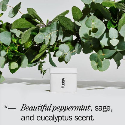 Fussy deodorant refill with green leaves in the background and text reading 'Beautiful peppermint, sage and eucalyputs scent'