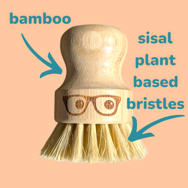 Wooden 'geeky' pot brush with a spectacled face design on a peach background with text "bamboo, sisal plant based bristles"
