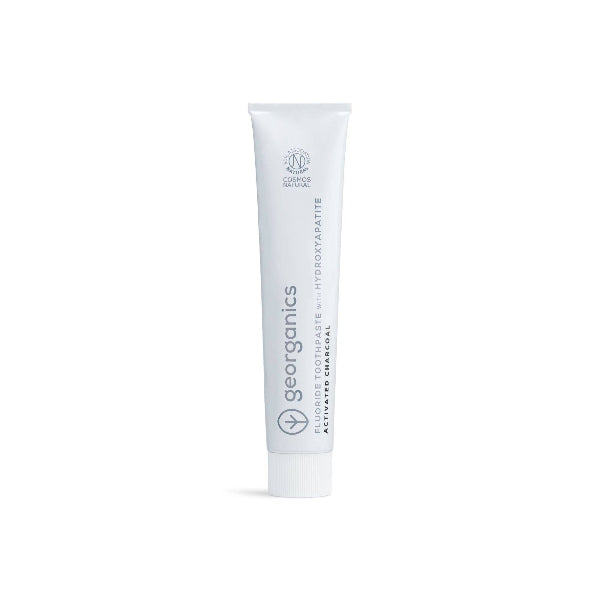 White tube of Georganics toothpaste activated charcoal on a white background