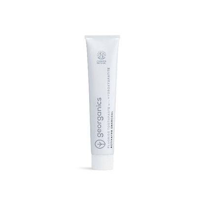 White tube of Georganics toothpaste activated charcoal on a white background