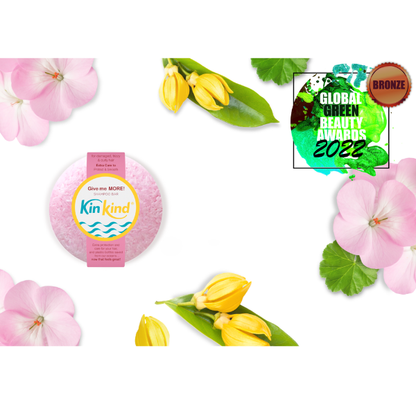 KinKind shampoo bar Give me MORE! surrounded by flowers and greenery, featuring a 'Bronze' award from Global Green Beauty Awards 2022.
