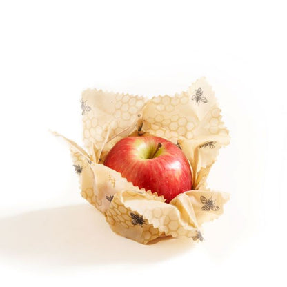 Beeswax wrap in honeycomb design wrapped around an apple