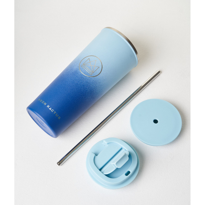 Insulated travel cup alongside metal straw, sipping lid and straw lid, in Good vibes colourway (darker blue at bottom graduating to pale blue at top)