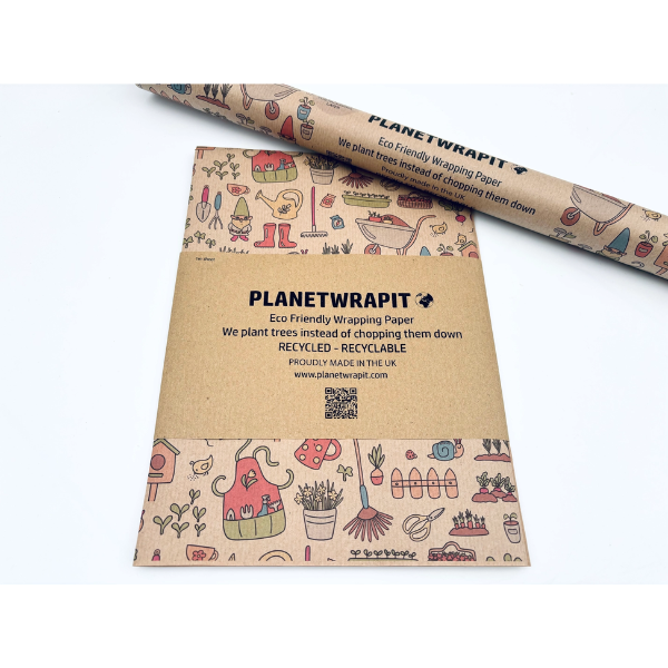 Planetwrapit eco-friendly wrapping paper folded and wrapped in a kraft paper band alongside a roll of paper, featuring a pattern of colourful gardening implements, plants, watering can etc on a brown kraft paper background.
