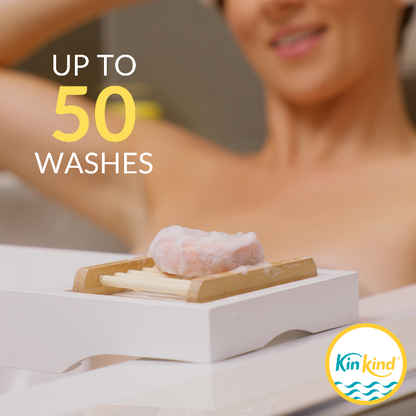 Person in a bath next to a soap dish with KinKind shampoo bar and text reading "up to 50 washes" 