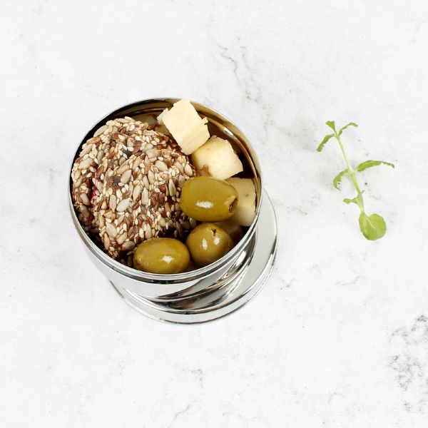 Stainless steel mini food container with lid shown off with olives , cheese and seeds inside