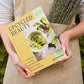 UpCycled beauty Book held in somebody's hand, standing outside wearing an apron with lavender