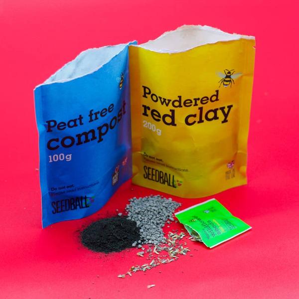 Two bags of compost and red clay on a pink background
