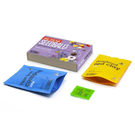 Seedball kit with packaging, coloured powders, and labels on a white background