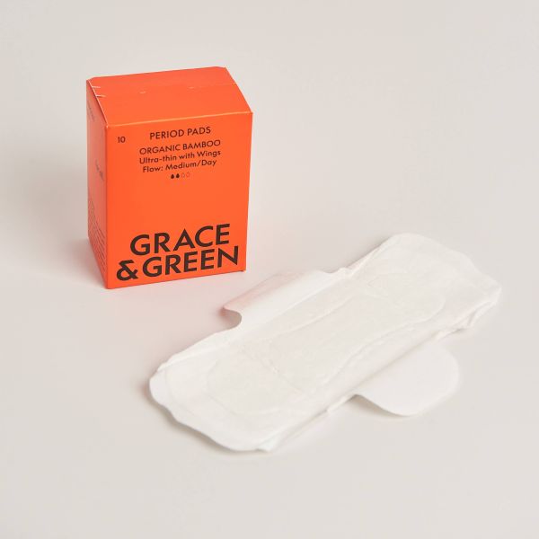 Red box of Grace & Green period pads with a pad alongside on a light background