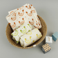 Organic cotton set of three muslin cloths, shown inside a basket with wooden child's blocks alongside.  All with cream background with colourful fruity images.