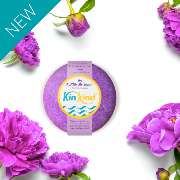 Purple shampoo bar with 'KinKind' branding surrounded by purple flowers on a white background