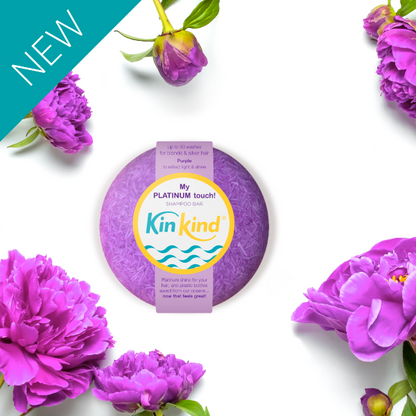 Purple shampoo bar with 'KinKind' branding surrounded by purple flowers on a white background