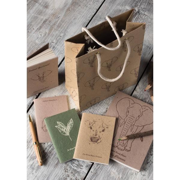 Set of notebooks and a gift bag with animal illustrations on a wooden surface