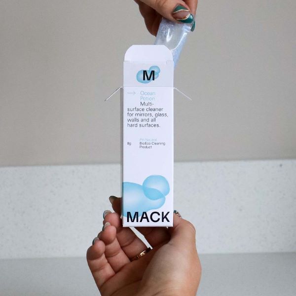 Ocean potion multi-surface cleaner dissolvable cleaning pod in cardboard packaging with a hand removing the pod from the box