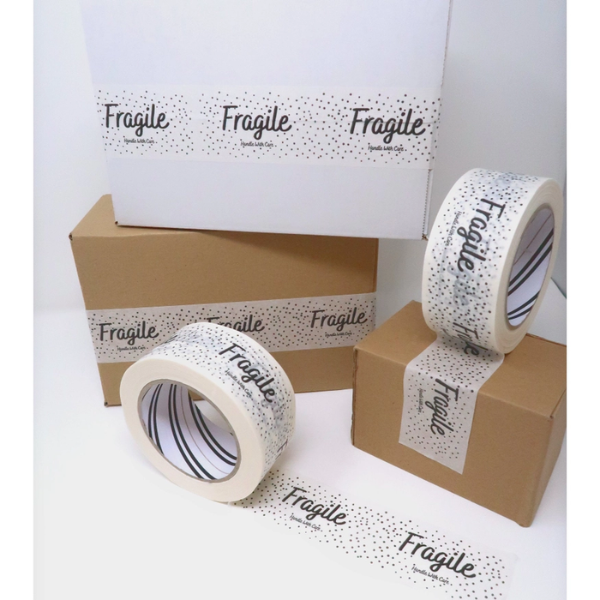 White paper tape with 'Fragile' text on roll and on boxes against a white background