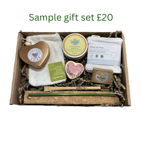 Sample personalised sustainable gift set worth £20 with soap in a heart tin, bamboo soap bag, forget-me-not seed sticks, body scrub, reusable makeup pads, natural spa facial soap, cardboard pen, neon stainless steel straw in cork carry pouch. 